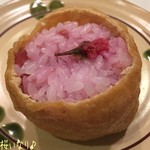 おむすび権米衛 - お目当ての桜いなり(150円)♪ 春の期間限定品みたいだね☆彡
桜いなりは桜色の酢めしごはんに小梅を混ぜ込んでてカリカリ食感良く、桜の塩漬けが乗ってる春らしいお稲荷さん♪ お揚げもジューシィで旨〜！