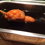 948 串と饂飩 - 「おまかせ 10本セット」の串かつ「じゃがいも」を特製ソースに浸しているところ。2度漬け禁止のソースもまた、本場『だるま』や『じゃんじゃん』などのものと似た味わいで、「ああ、この味だよな」と言う大阪の味であった。