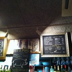 ビストロ酒場マエストロ - 高いカウンターの上の額に入ったメニュー