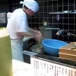 手造りうどん 楽々 - 鍋を激しくかき混ぜながら、生のうどんを投入