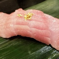 鮨隆 - ②大トロ、金箔のせ(産地説明無)
                  金箔とのコントラストがまぶしいピンク色の大トロ。
                  筋の入り方は中トロですが、養殖マグロのようで脂が回り過ぎて大トロ化しています。