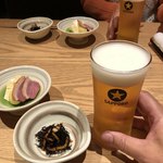 味噌漬け 粕漬け くらま - 《生ビールとおつまみセット》の生ビール・グラス、お通し、おつまみ三品盛り(この他に、本日の味噌漬け焼き魚)