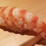 鮨 さかい - ⑦車海老(長崎県五島列島産)
      奥の厨房で茹でたての温かい車海老。
      お弟子さんが熱々を一生懸命剥いている様です。
      車海老はぷりぷり、シャリはググッと沈み込みます
      車海老の華やかな甘みと旨味が押し寄せます