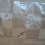 餅工房 おくやま - 包み紙。雁月、あん餅、おこわなどの字が見られます。