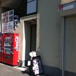 ベジタリアンの風 - 看板が目印。店は奥に入口。
