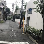 AMOUR - 明治通りからお店を見た様子
      右奥に見える黒い塀がお店の目印です