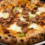 ピッツェリア・エ・バール・レガーメ - 生地重量300gを手延ばし薄くトマトソースを塗った上に自家製サルシッチャ、ンドゥイヤ少々、枝豆散りばめ高山産モッツァレッラを載せ、グラナパダーノ振り掛けて薪窯へ。180度位置替えするだけで焼くだけ。こんなに旨いピッツァ、ここ以外で食べられないと思います。