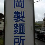 岡製麺所 - お店の看板です。 岡製麺所って青の文字で書いていますね。 シンプルでいい感じですね。