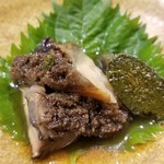鮨匠 のむら - ⑩黒鮑(佐賀県唐津産)の柔らか煮
      産卵期は秋～冬(禁漁)、旬は初夏～夏。
      だから火入れしても大きさが変わらず、6時間も大根の煮汁で煮るので大変柔らかく、その身がプルプルと震えるほどで旨みも抜群です。