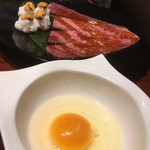 焼肉門門 - 雲丹手毬寿司をサーロインで包み卵に潜らせていただきます。卵からのショット。