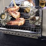 すしごはん 馬ん場 - 磯浜焼きの海老とサザエを焼いています。
      奥には、焼きおにぎりセットもスタンバイ。