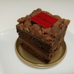 ドゥブルベ・ボレロ - アーモンドパウダーやカカオ分70％のダークチョコの重厚な生地と、ミルクチョコベースのガナッシュ、香ばしいヘーゼルナッツのプラリネ和え