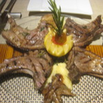 トラットリア ダイ パエサーニ - 骨付き仔羊肉のグリル。1ピース足して4ピースにしてもらった。見せてもらったジャガイモが異様に大きかったがそういう品種？