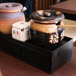 築地ダイニング 金のうなぎ - 右側のツボがたれ、中央の四角い小さい容器が山椒、左側は漬物