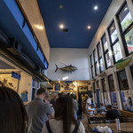 Blue Water Seafood Market & Grill - 店舗に入ったところ。正面に行列、左に魚介販売ショーケース、右に室内席、さらに写真には写っていませんが右ガラス壁の外がテラス席です。
