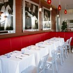 ブラッスリー ポール・ボキューズ - ボキューズ氏のテーマカラー「赤」と白を基調とした明るい店内。壁にはリヨンのブラッスリーの写真。