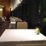 OTTO SETTE - 円弧を描くように配置された窓際席。テーブルの上には、それぞれの生花