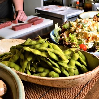 Large plates of seasonal obanzai dishes are lined up on the counter at night.