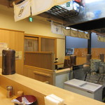 Maruuma Udon - 店内、立ち食いカウンターですが、もう一つ入口が…
