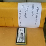 ちゅるるちゅーら ラーメン研究所 - 開店時間遅延の案内と順番待ち札。