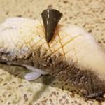 鮨匠 のむら - 握り⑭黒鮑(佐賀県唐津産)の柔らか煮
      火入れしても大きさが変わらず、6時間煮込んでも大きいままなんだとか。
      大根の煮汁で煮るので大変柔らかく、その身がプルプルと震えるほど。
      旨みも抜群です。