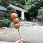 山寺 - 《力こんにゃく》1本100円。奥に見えるのは山寺の山門。