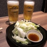九州料理×もつ鍋 九州小町 - 生ビール（一番搾り） この日は66円 お通しはキャベツ