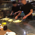 Hiroshima Okonomiyaki Teppanyaki Kurahashi - 目の前の鉄板で手際よくお好み焼きを焼いています。