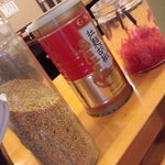 博多まんまる - 卓上調味料の一部。紅ショウガ、粒ゴマ、黒コショウが置いてある