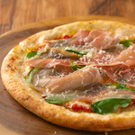 Fresh pizza with prosciutto and arugula