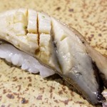 鮨匠 のむら - (25)炊き黒鮑(佐賀県唐津産)
      産卵期は秋～冬(禁漁)、旬は初夏～夏。
      6時間、大根の煮汁100%で炊き込んだ黒鮑は、大変柔らかく、その身がプルプルと震え、旨みも抜群です。