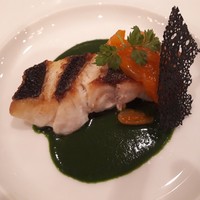 アルピーノ - 鰆のポワレ　小松菜とアサリのソース
                黒い網目状のはひよこ豆にイカスミを混ぜて焼いたものらしい。