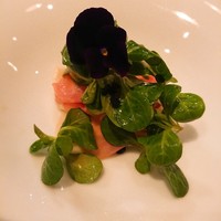 ル・ミロワール - ホタテのポワレの上に生ハム。
                食用パンジーも乗って見た目美しい前菜。
                プリプリに良い焼き加減のホタテ！