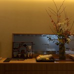 丸新 - カウンターの中はいつも綺麗な生け花が。