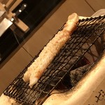 はらまさ - 七輪で焼かれるカニの足