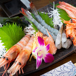 Four platters of shrimp sashimi