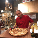 フォカッチャディレッコ500 - このお店のオーナーシェフ。イタリア本場仕込みの腕は確かです。焼き上がったこのお店の名物「フォカッチャディレッコ」を手に。これで6人前あります。