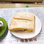 Nam Ping - 叉焼蛋文治。チャーシューとスクランブルエッグのサンドウィッチ。マカオの茶餐廳は料理名が香港と同じだから分かりやすい。例えばサンドウィッチは香港では三文治、大陸では三明治。親指の跡がやるせない。