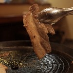 京の韓国家庭料理 ハムケ - 傾斜がついた中心の穴から油が落ちる専用鉄鍋で三枚肉をよく焼き（サムギョプサル）